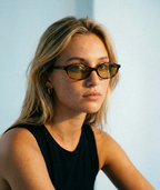Model wearing Cleo cat-eye sunglasses in tortoise with green lenses