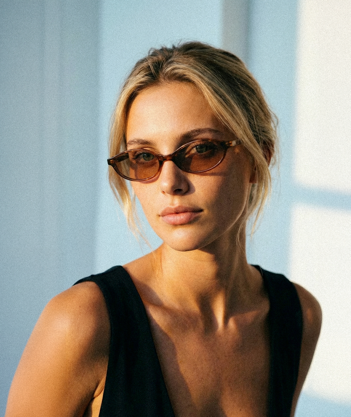 Model wearing Cleo cat-eye sunglasses in transparent brown with brown lenses