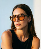 Model wearing Mirage aviator sunglasses in tortoise with orange lenses