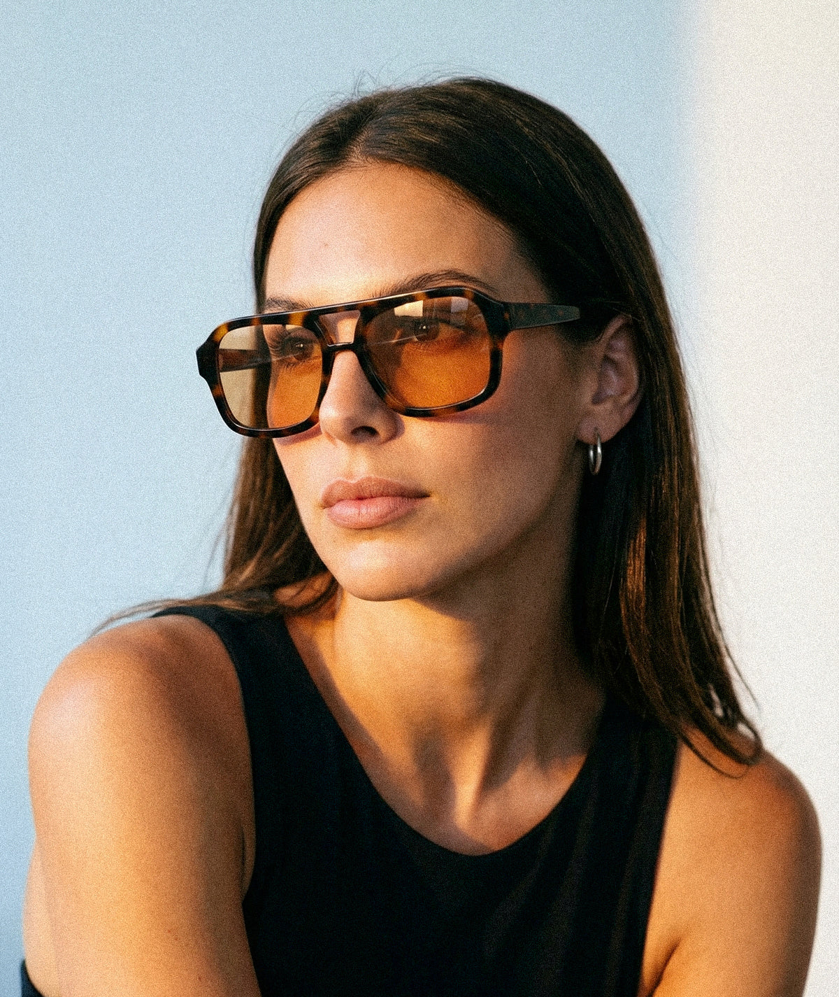 Model wearing Mirage aviator sunglasses in tortoise with orange lenses