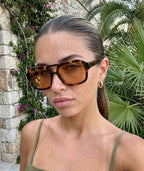 Model wearing Mirage aviator sunglasses in tortoise with orange lenses